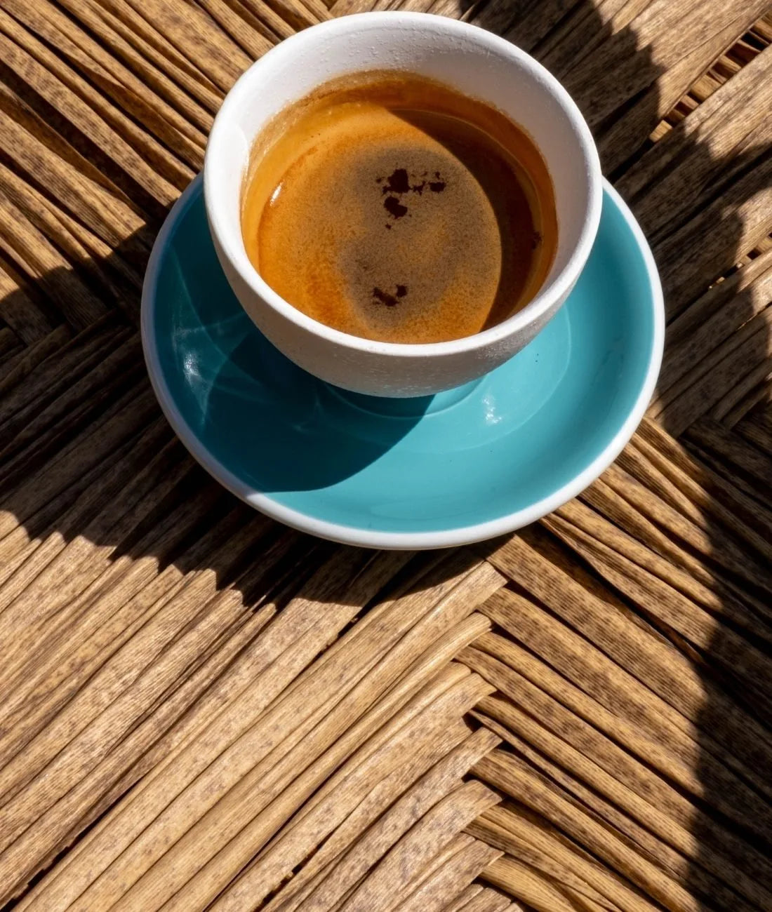 Café expresso dans une petite tasse, délicatement posé sur des palmiers