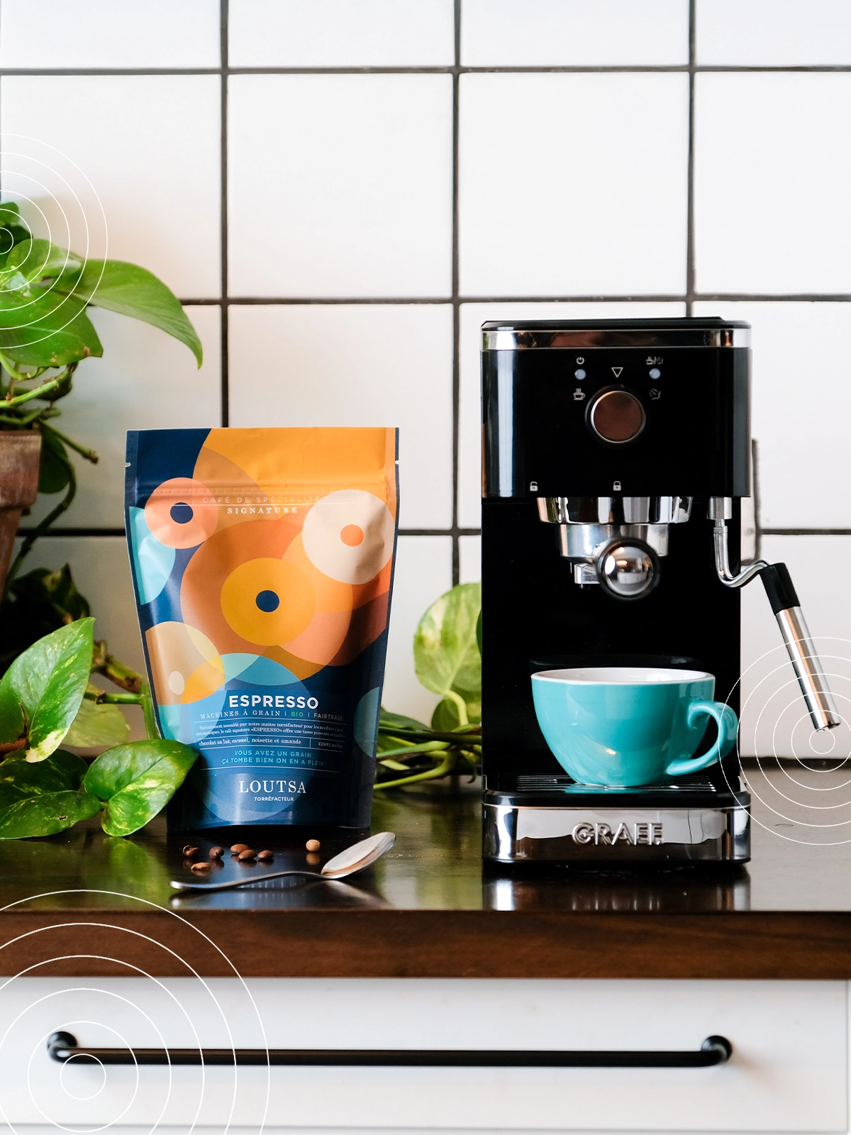 machine à café sur un plan de travail, avec un sachet de café ESPRESSO LOUTSA et une tasse 